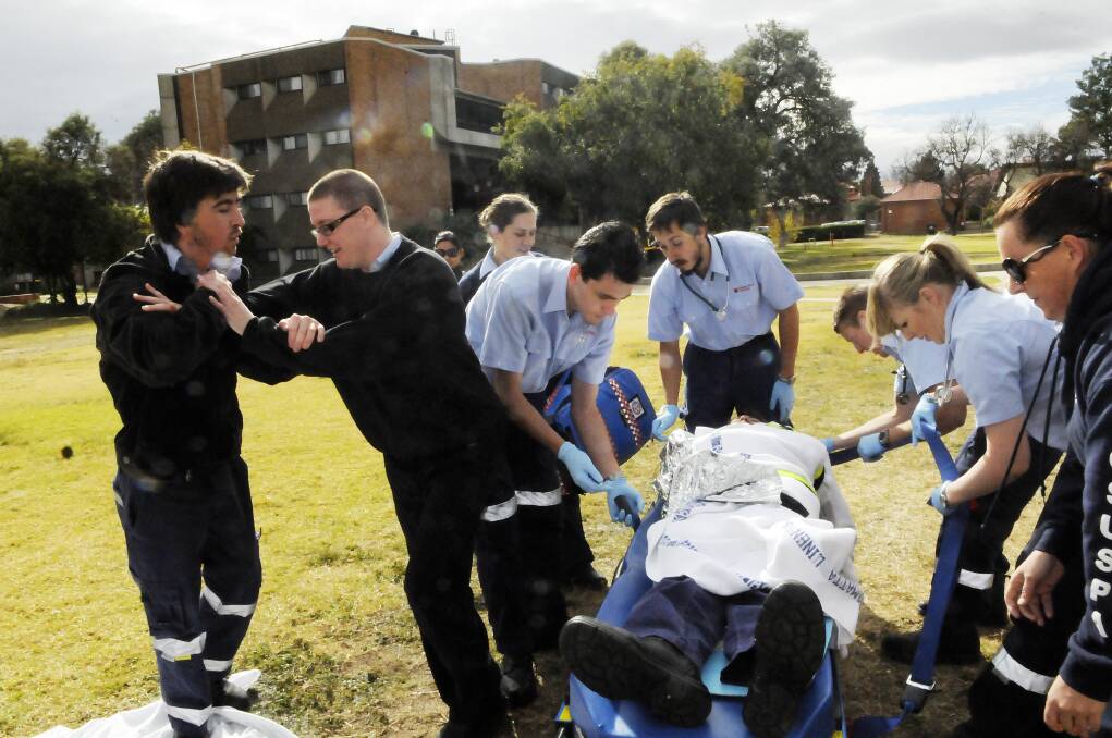 DIFFICULT SITUATION: In a simulation exercise, CSU paramedics student Lucy Weiner attempts to hold off Scott Parkinson, who is acting aggressively towards paramedics. Photo: PHILL MURRAY 052113ppara1