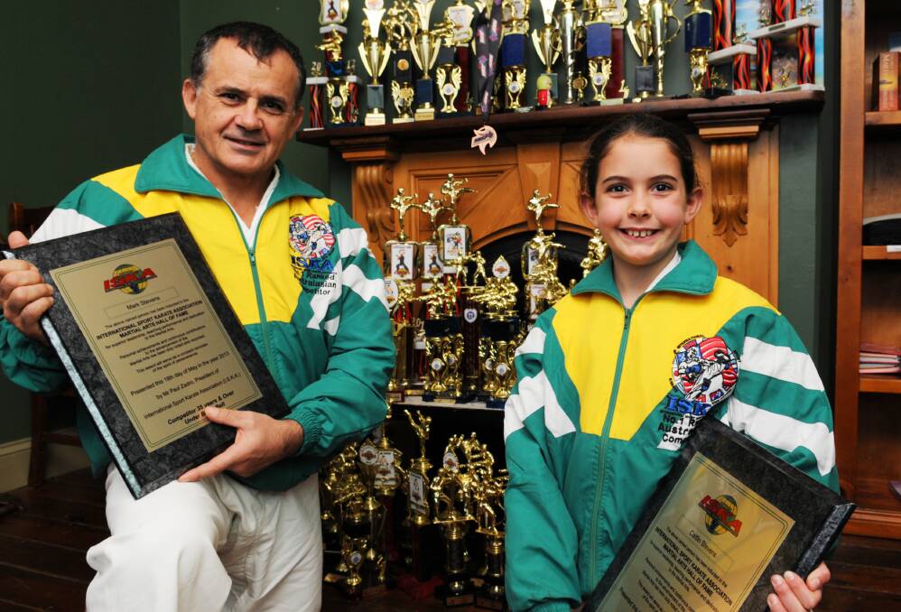 HIGH ACHIEVERS: ISKA Hall of Fame inductees Mark and Caitlin Stevens along with some of the trophies they have accrued since the start of 2012. Photo: ZENIO LAPKA 	061313zkarate