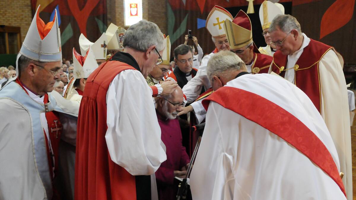 The bishops present lay their hands on the head of bishop-elect Ian Palmer. Photo: PHILL MURRAY
