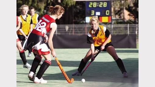 2009: Dubbo Senior College’s Emily Ainsworth moves the ball forward as Orange High’s Kate Butcherine lines up in defence. Orange High easily claimed the Astley Cup hockey game 5-nil.