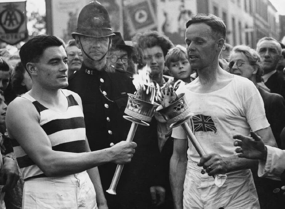 Veteran runner H J Bignall (right) hands over the Olympic torch to Fred Prevett at Redhill, Surrey, during the flame's journey from Dover to Wembley Stadium, London, for the opening of the 1948 London Games. Photo: Getty Images